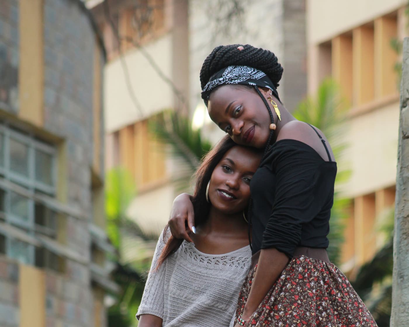 Two friends embracing and smiling on a city street